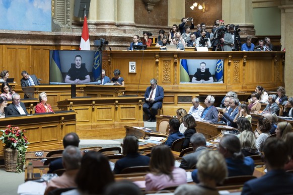 Ukrainian President Volodymyr Zelensky is displayed on screens during his speech to the members of the Swiss parliament, in Bern, Switzerland, Thursday, June 15, 2023. (KEYSTONE/Peter Klaunzer)