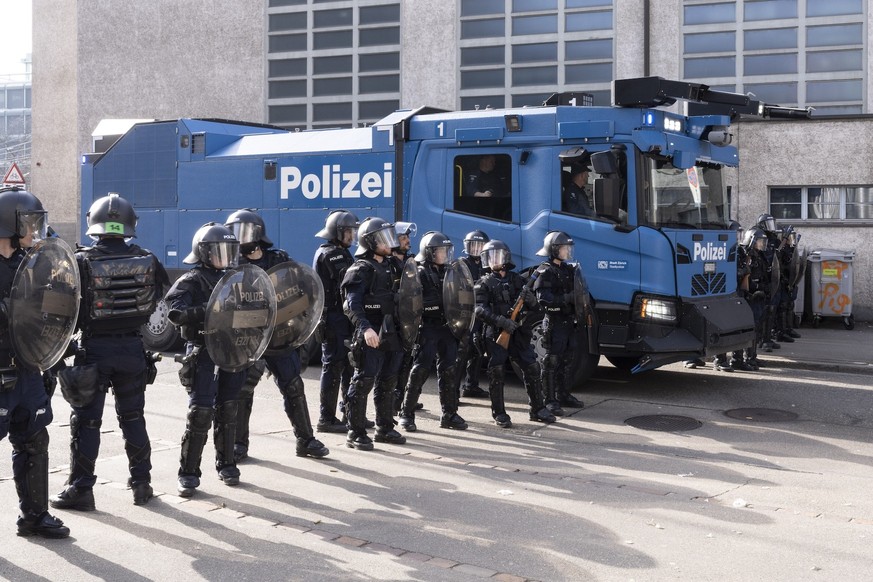 Des policiers se tiennent près d'un canon à eau lors d'une manifestation marquant la Journée internationale des femmes à Zurich, en Suisse, le samedi 7 mars 2026.