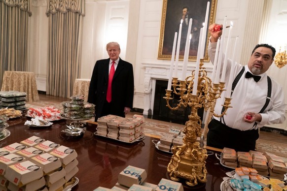 WASHINGTON, DC - JANUARY 14: (AFP OUT) U.S President Donald Trump watches as candles are lit as he presents fast food to be served to the Clemson Tigers football team to celebrate their Championship a ...