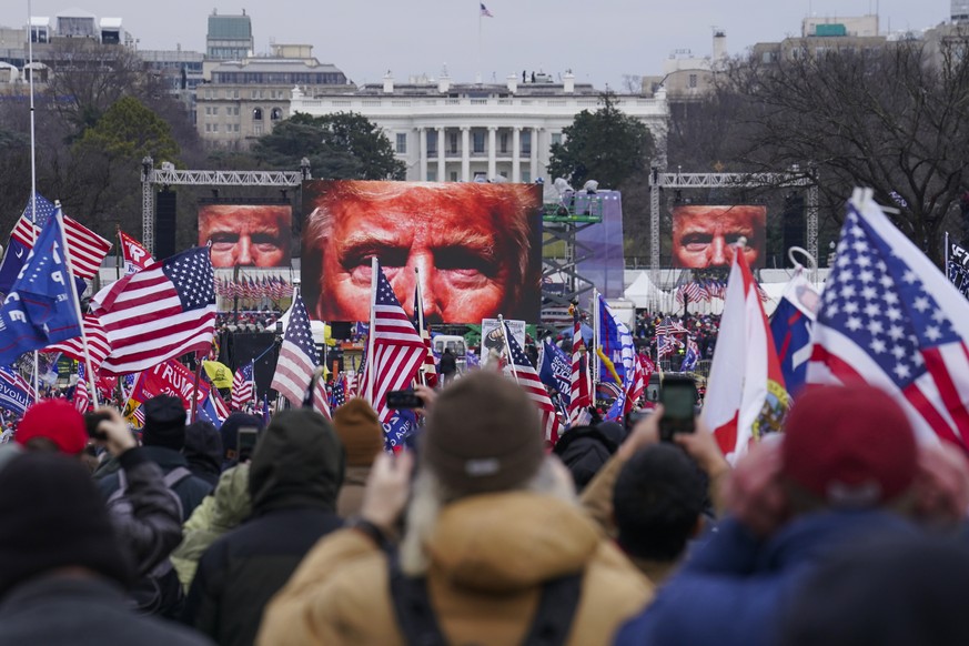 FILE - The face of President Donald Trump appears on large screens as supporters participate in a rally in Washington, Jan. 6, 2021. Members of the House committee investigating the events of Jan. 6 w ...