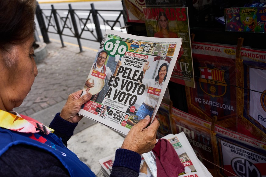 A newspaper vendor reads the front page of a newspaper that reads in Spanish: "The fight is vote by vote" in Lima, Peru, Monday, June 8, 2026, a day after the presidential election runoff. ( ...