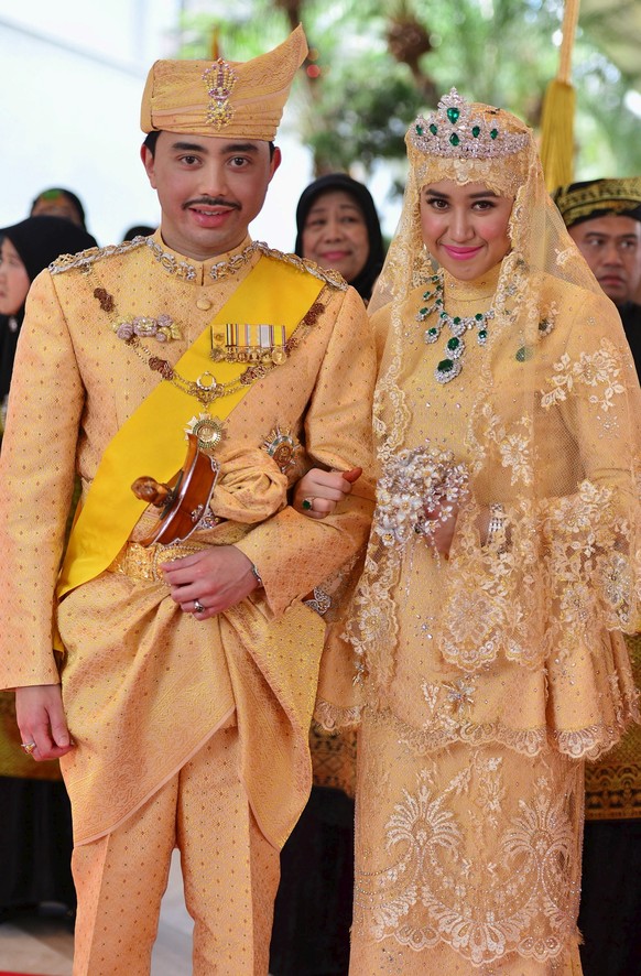 Brunei's newly wed royal couple, Prince Abdul Malik and Dayangku Raabi'atul 'Adawiyyah Pengiran Haji Bolkiah, pose for photographers after the "bersanding" or enthronement cer ...