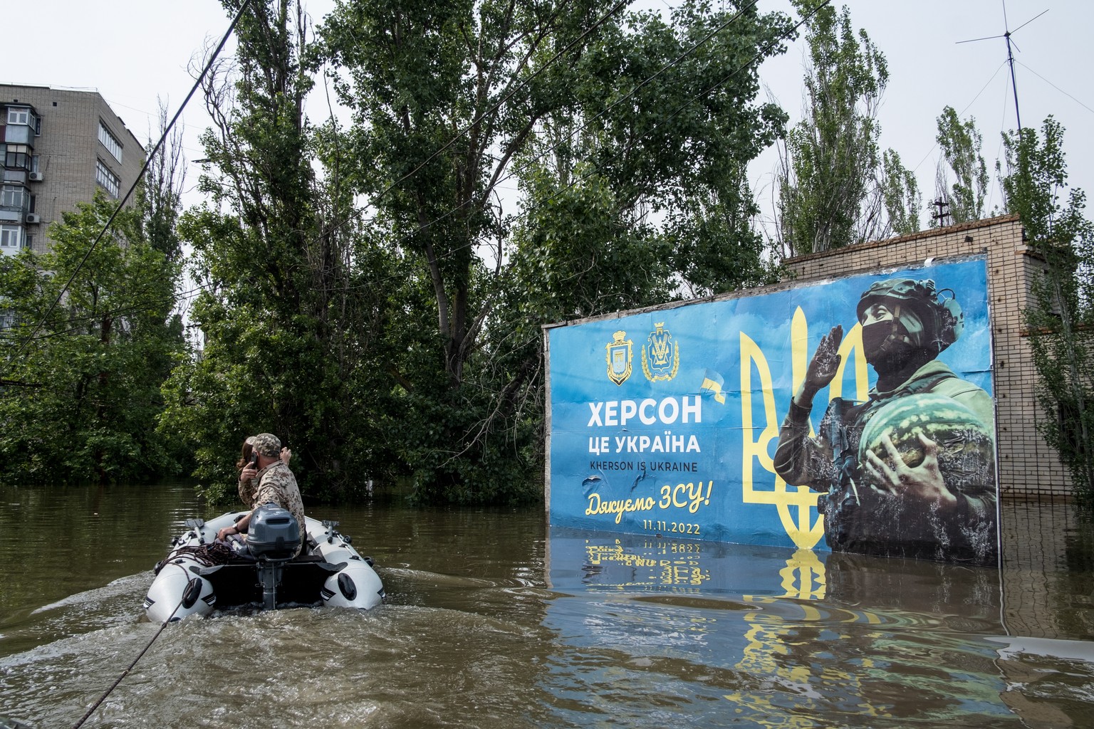 epa10678569 Residents use a rubber boat as they evacuate from a flooded area of Kherson, Ukraine, 07 June 2023. Ukraine has accused Russian forces of destroying a critical dam and hydroelectric power  ...