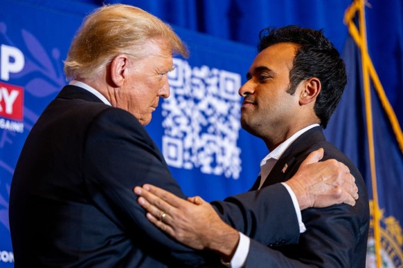 ATKINSON, NEW HAMPSHIRE - JANUARY 16: Republican presidential candidate, former U.S. President Donald Trump greets U.S. entrepreneur Vivek Ramaswamy while speaking during a campaign rally at the Atkin ...