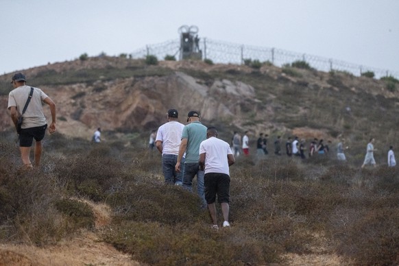 epaselect epa13142959 People gather on a hill near the Bab Sebta border crossing between Morocco and the Spanish enclave of Ceuta, near Fnideq, Morocco, 30 July 2026. Hundreds of people headed toward  ...