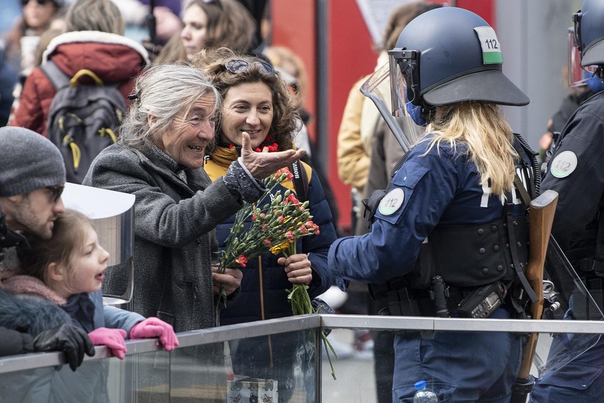 Zwei Frauen diskutieren mit einer Polizistin bei einer Demonstration gegen die verordneten Corona Schutzmassnahmen, am Samstag, 20. Maerz 2021, in Bern. (KEYSTONE/Peter Schneider)