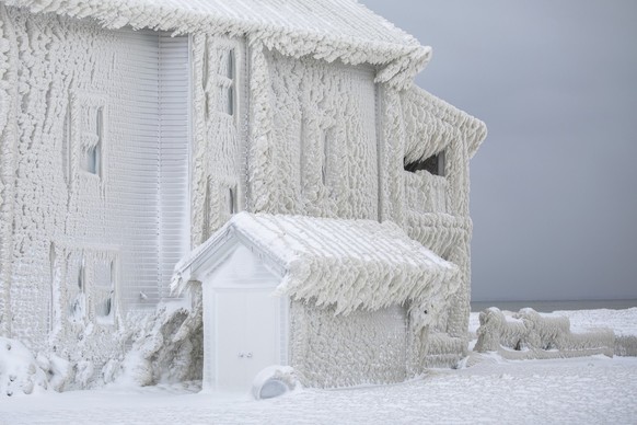 Houses along the shores of Lake Erie, near Fort Erie, Ontario, remain covered in ice Tuesday, Dec. 27, 2022, following a winter storm that swept through much of Ontario. (KEYSTONE/The Canadian Press v ...