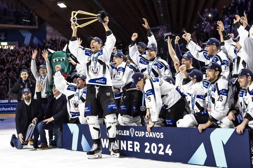 Fribourg's Julien Sprunger lifts the trophy after the final game between Germany's Straubing Tigers and Switzerland's HC Fribourg-Gotteron at the 96th Spengler Cup ice hockey tournament ...