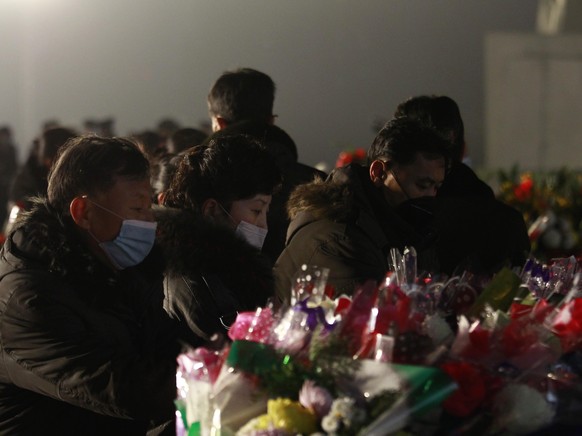 Citizens lay bouquets of flowers at the bronze statues of their late leaders Kim Il Sung and Kim Jong Il on Mansu Hill in Pyongyang, North Korea Thursday, Dec. 16, 2021, on the occasion of 10th annive ...