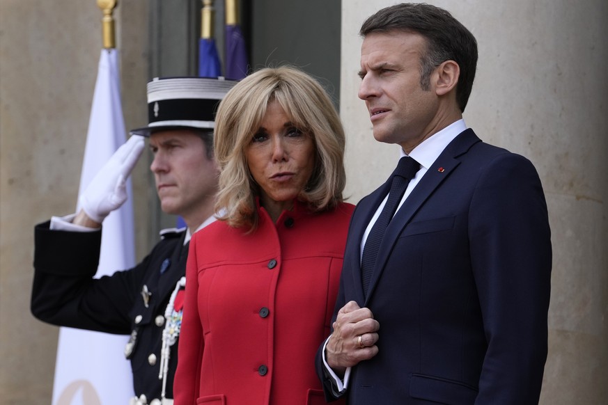 FILE - French President Emmanuel Macron and his wife Brigitte Macron wait for China&#039;s President Xi Jinping and his wife Peng Liyuan at the Elysee Palace, Monday, May 6, 2024 in Paris. (AP Photo/T ...