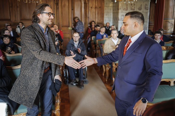 Julien Wicki, candidat du parti socialiste, (gauche) et le candidat Ruben Ramchurn (droite) se serent la main apres l&#039;annonce des resultats du 2e tour de l&#039;election complementaire a la munic ...
