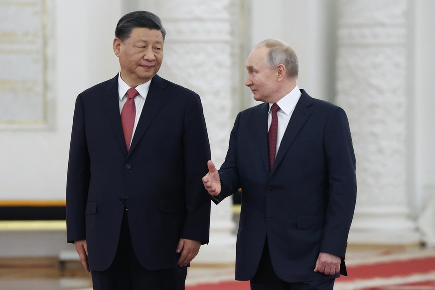 Russian President Vladimir Putin, right, speaks to Chinese President Xi Jinping as they attend an official welcome ceremony at The Grand Kremlin Palace, in Moscow, Russia, March 21, 2023. Chinese lead ...