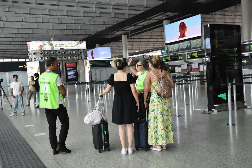 epa13166965 Travelers at Fontanarossa Airport in Catania, Italy, 13 August 2026. All flights arriving at and departing from Catania Airport have been suspended due to heavy ashfall caused by activity  ...