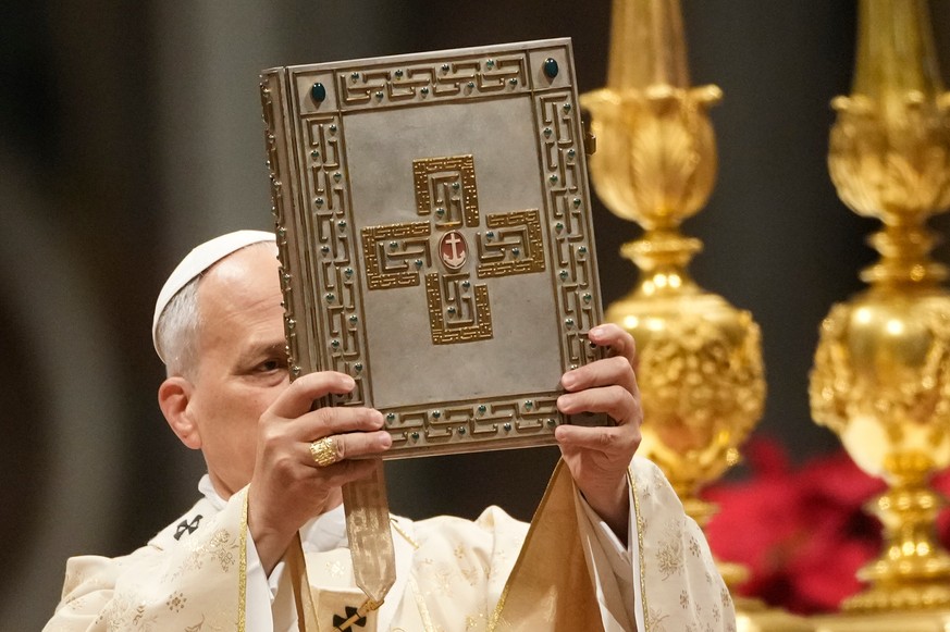 Pope Leo XIV holds up the book of the Gospel during the Christmas Day Mass at the St. Peter's Basilica at the Vatican, Thursday, Dec. 25, 2025. (AP Photo/Gregorio Borgia)
Vatican Pope Christmas
