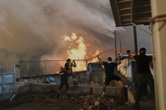 A firefighter and men try to control the fire approaching a house during a wildfire in Patras city, western Greece, Wednesday, Aug. 13, 2025. (AP Photo/Thanassis Stavrakis)
APTOPIX Greece Wildfires