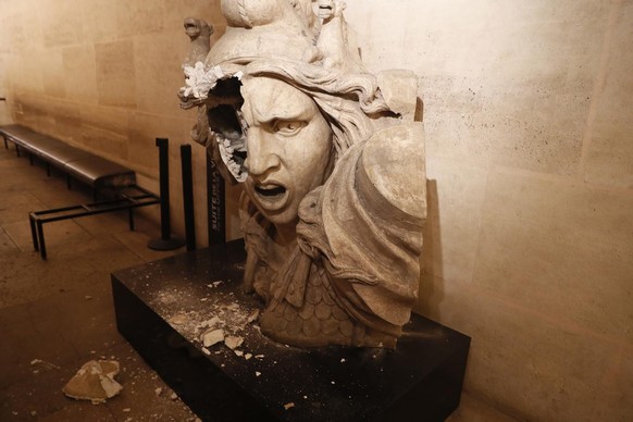 epa07201823 A vandalizes statue of the Marianne, a symbol in France, seen inside the Arc de Triomphe, as protesters wearing yellow vests (gilets jaunes) entered the Arc de Triomphe monument during cla ...