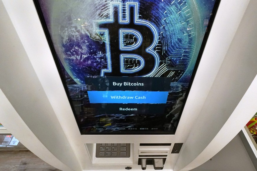 FILE - The Bitcoin logo appears on the display screen of a cryptocurrency ATM in Salem, N.H., Feb. 9, 2021. The U.S. for the first time has given the greenlight to almost a dozen exchange traded funds ...