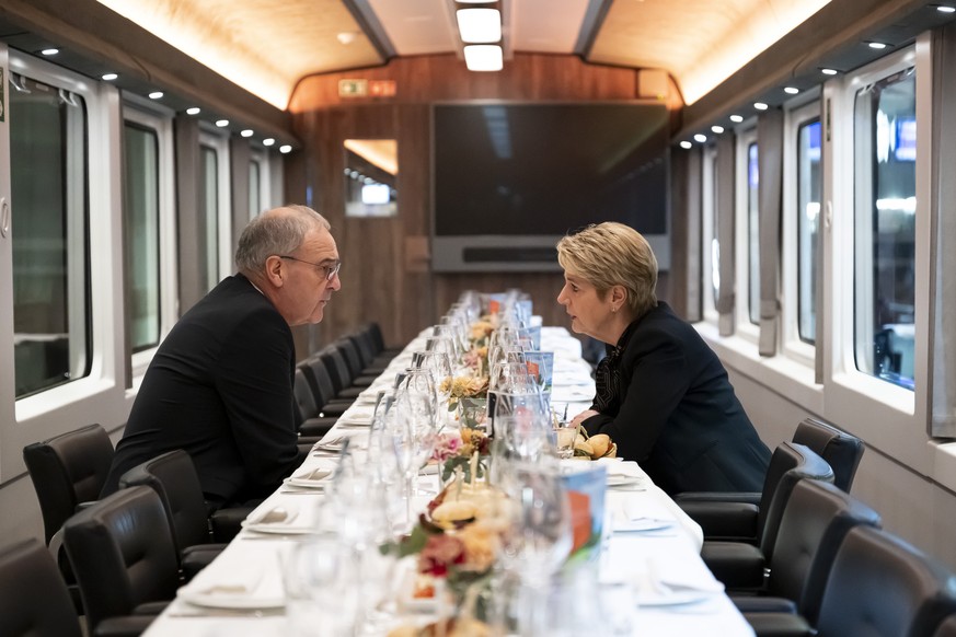 Le president de la confederation nouvellement elu Guy Parmelin, a gauche, et la Presidente de la Confederation Karin Keller-Sutter, a droite, discutent dans un train special des CFF en direction de Fr ...