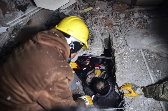 Emergency workers and medics rescue a woman out of the debris of a collapsed building in Elbistan, Kahramanmaras, in southern Turkey, Tuesday, Feb. 7, 2023. Rescuers raced Tuesday to find survivors in ...