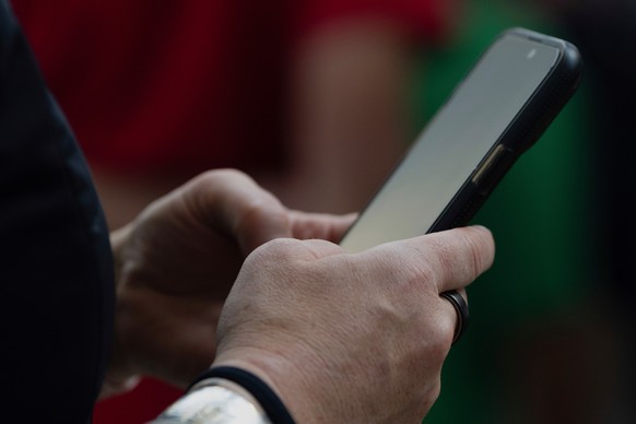 FILE - A person looks at their phone at Seattle?Tacoma International Airport on Sunday, June 1, 2025, in Seattle. (AP Photo/Jenny Kane, File)
iphone,phone,apps,applications,technology