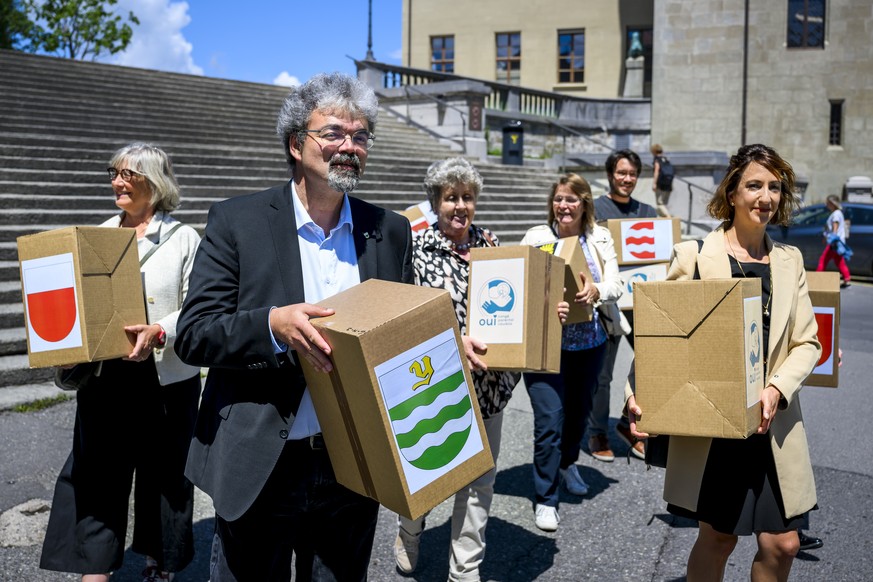 Pierre Dessemontet, gauche, Syndic d&#039;Yverdon et Jessica Jaccoud, droite, president du PS Vaud ainsi que des membres du parti socialiste et des Verts vaudois portent des cartons de signatures lors ...