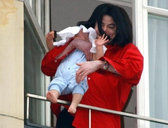 PA PHOTOS/DPA - UK USE ONLY : US pop star Michael Jackson is holding his youngest son Prince Michael II with just one arm over the balustrade of the window of the president&#039;s suite on the fifth f ...