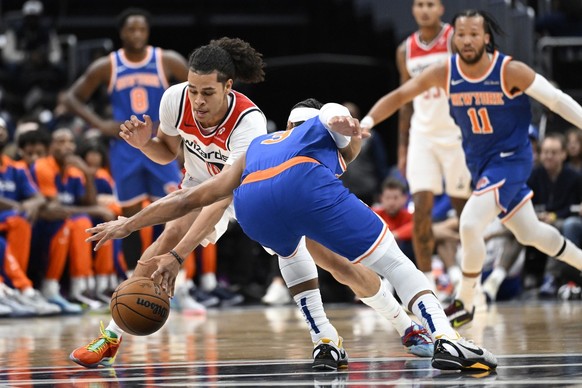 Washington Wizards forward Kyshawn George, left, attempts to steal the ball from New York Knicks guard Josh Hart (3) during the first half of an NBA preseason basketball game Friday, Oct. 18, 2024, in ...