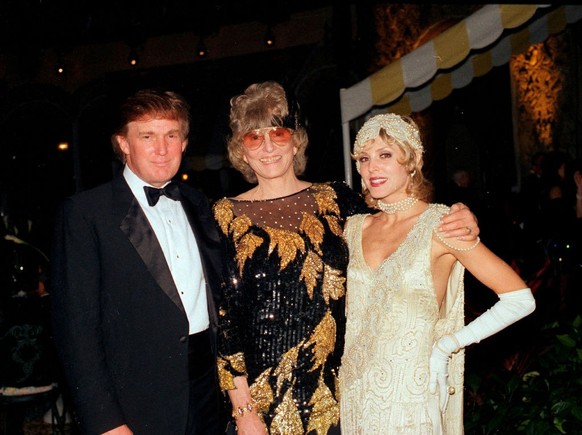 Married American couple, real estate developer Donald Trump (left) and actress Marla Maples (right), stand with former competative swimmer Marjorie Post Dye (1928 - 2015) (center) on stage during a &# ...