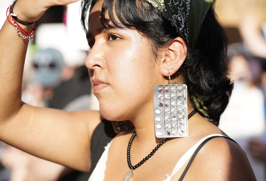 Esme Ledezma wears earrings made out of birth control pills during a protest against the Supreme Court&#039;s decision to reverse Roe v. Wade at the Federal Courthouse on Friday, June 24, 2022 in Hous ...