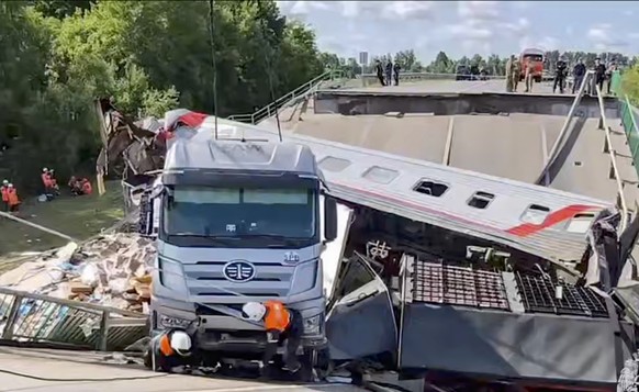 epa12148775 A handout still image taken from handout video provided by Russian Emergencies Ministry press-service shows Russian rescuers working at the site after a bridge collapsed on a passenger tra ...