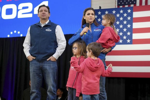 FILE - Republican presidential candidate Florida Gov. Ron DeSantis, left, looks on as his wife Casey DeSantis, carrying daughter Mamie, speaks during a campaign event at The Hangout on Saturday, Jan.  ...