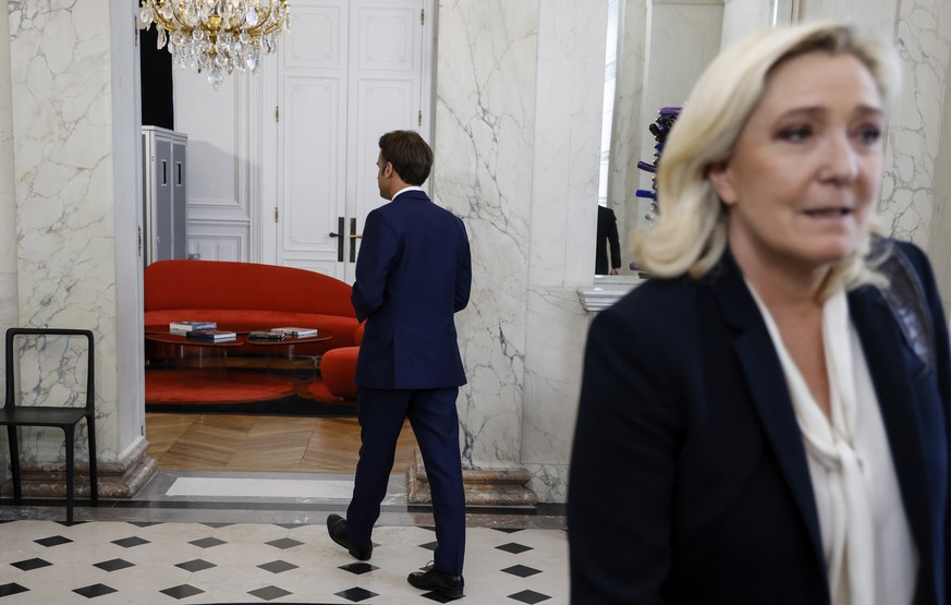 French President Emmanuel Macron, leaves, after a meeting with French far-right Rassemblement National (RN) leader and Member of Parliament Marine Le Pen at the Elysee Palace in Paris, France, Tuesday ...