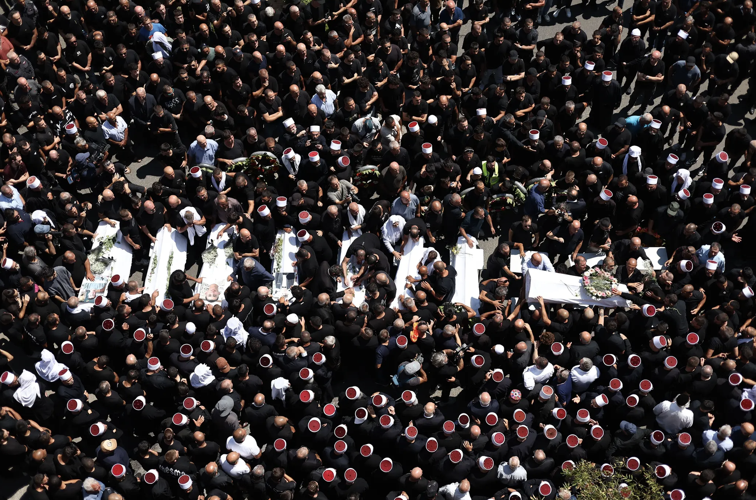 Des centaines de membres de la famille druze et de connaissances portant leurs coiffes rouges et blanches ont pris part dimanche à la cérémonie commémorative pour les victimes des roquettes tuées.