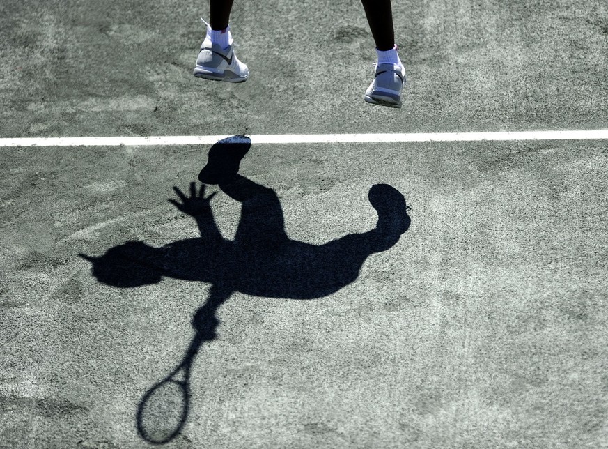 Venus Williams casts a shadow as she serves against her sister Serena Williams during the semifinals at the Family Circle Cup tennis tournament in Charleston, S.C., Saturday, April 6, 2013. Serena won ...