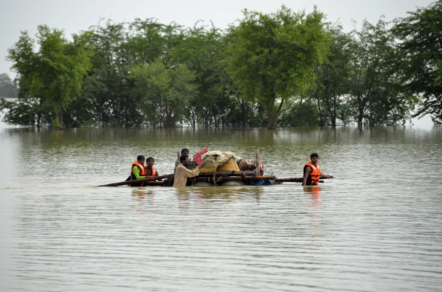 Displaced people transport usable belongings salvaged from their flood-hit home as they cross a flooded area in Sohbat Pur city of Jaffarabad, a district of Pakistan&#039;s southwestern Baluchistan pr ...