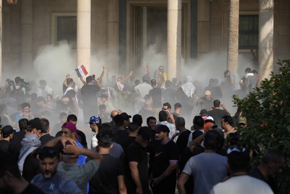 Iraqi security forces fire tear gas on the followers of Shiite cleric Muqtada al-Sadr inside the government Palace, Baghdad, Iraq, Monday, Aug. 29, 2022. Al-Sadr, a hugely influential Shiite cleric an ...
