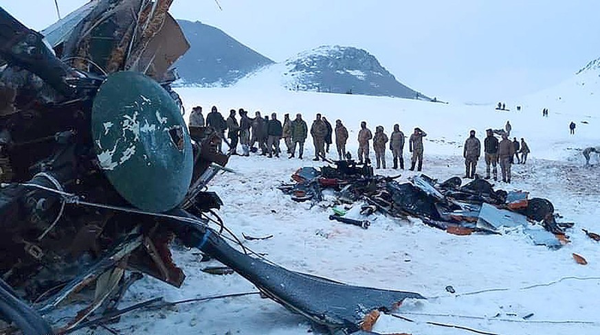 Soldiers and rescue workers stand around the wreckage after an army helicopter crashed in Bitlis, eastern Turkey, Thursday March 4, 2021. Turkey