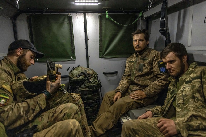 epa09936237 Ukrainian soldiers who sustained concussions after fighting with Russian troops around Popasna, sit in a military ambulance as they are being transported to a hospital from the frontline f ...