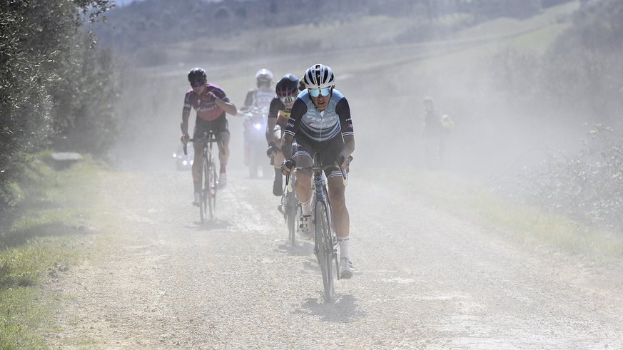 Competitors make their way in the dust during the Strade Bianche (White Roads) cycling race, near Siena, Italy, Saturday, March 6, 2021. (Marco Alpozzi/LaPresse via AP)