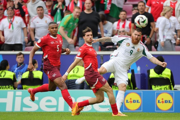 15.06.2024, Nordrhein-Westfalen, Köln: Fußball: UEFA Euro 2024, EM, Ungarn - Schweiz, Vorrunde, Gruppe A, Spieltag 1, Köln Stadion, der Schweizer Leonidas Stergiou (M) in Aktion gegen Ungarns Martin A ...