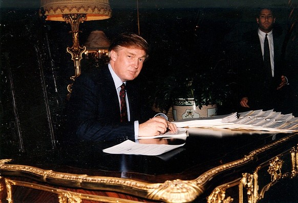 Portrait of American businessman Donald Trump as he signs documents at a desk in the Mar-a-Lago estate, Palm Beach, Florida, 1995. (Photo by Davidoff Studios/Getty Images)