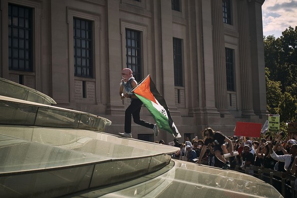 A Pro-Palestinian protester waves a flag over the Brooklyn Museum during a protest demanding a permanent cease-fire in Gaza on Friday, May 31, 2024, in the Brooklyn borough of New York. (AP Photo/Andr ...