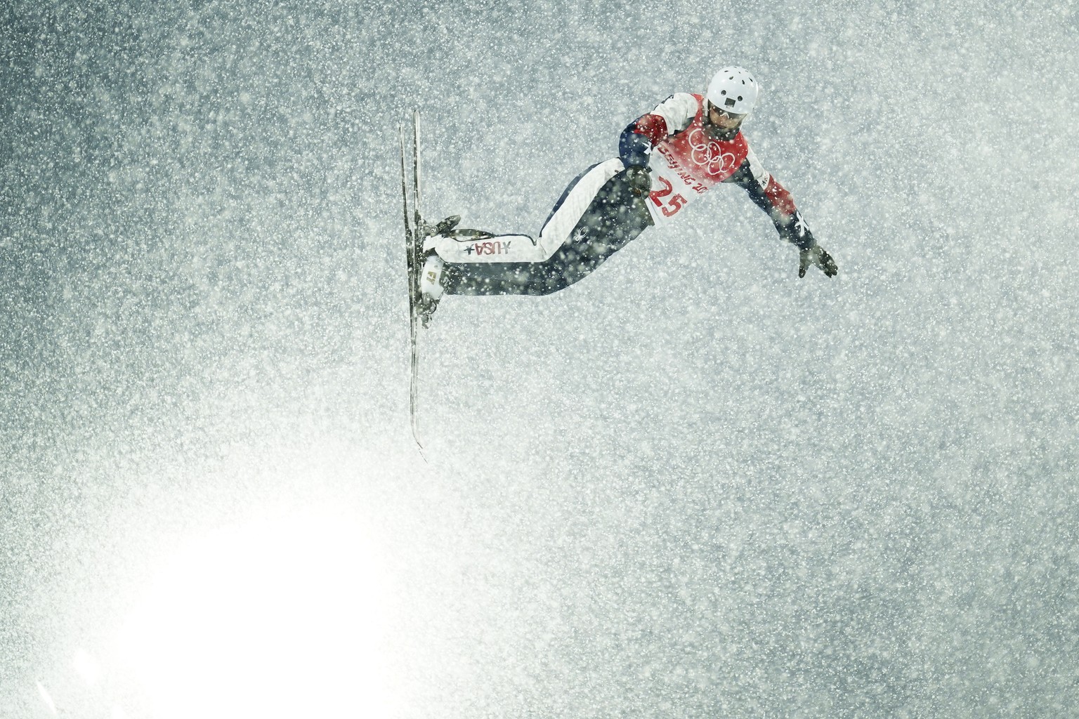 L'athlète d'Aerials Megan Nick s'envole à travers l'épais brouillard de neige.