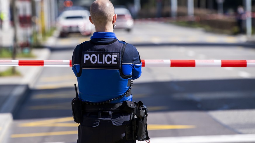 Un policier patrouille autour du gymnase de Beaulieu apres une alerte a la bombe le mercredi 24 mars 2021 a Lausanne. (KEYSTONE/Jean-Christophe Bott)