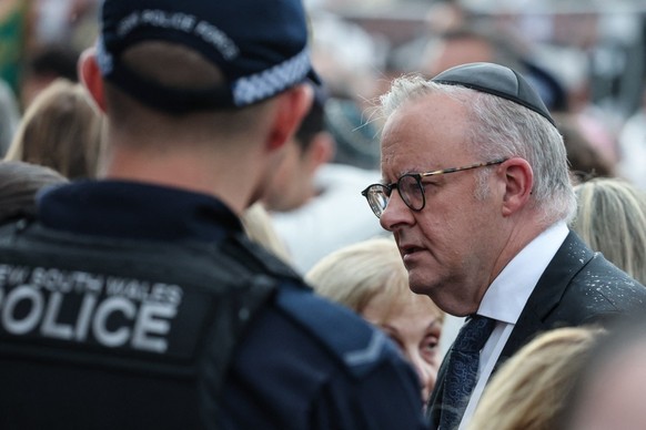 Australia's Prime Minister Anthony Albanese (R) wears a kippa as he arrives to attend the memorial held for the victims of a shooting at Bondi Beach in Sydney on December 21, 2025. A father and h ...