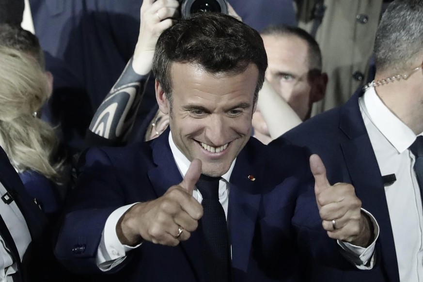 French President Emmanuel Macron thumbs up after reports of his reelection Sunday, April 24, 2022 in Paris. French President Emmanuel Macron appeared to comfortably win reelection Sunday in a runoff,  ...