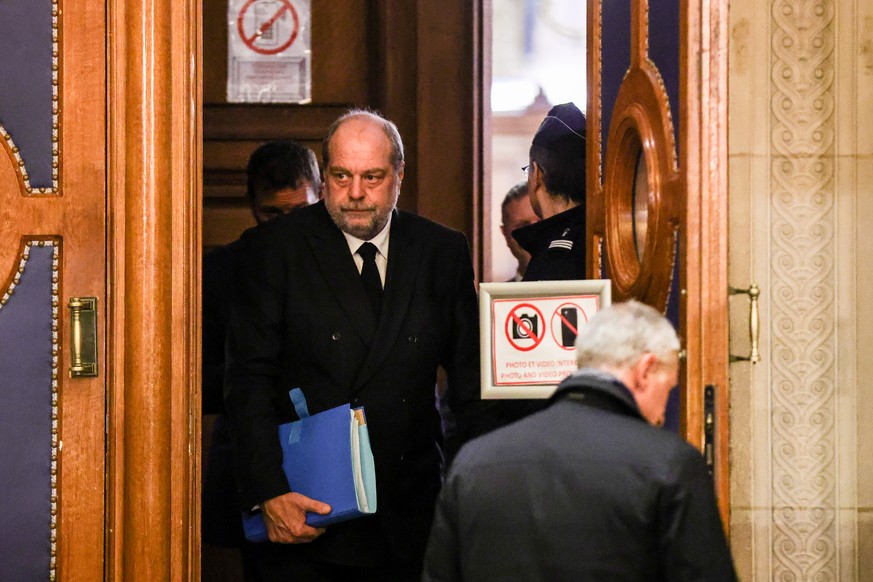 Eric Dupond-Moretti lundi à sa sortie de la salle d'audience du palais de justice de Paris, un épais dossier sous le bras.