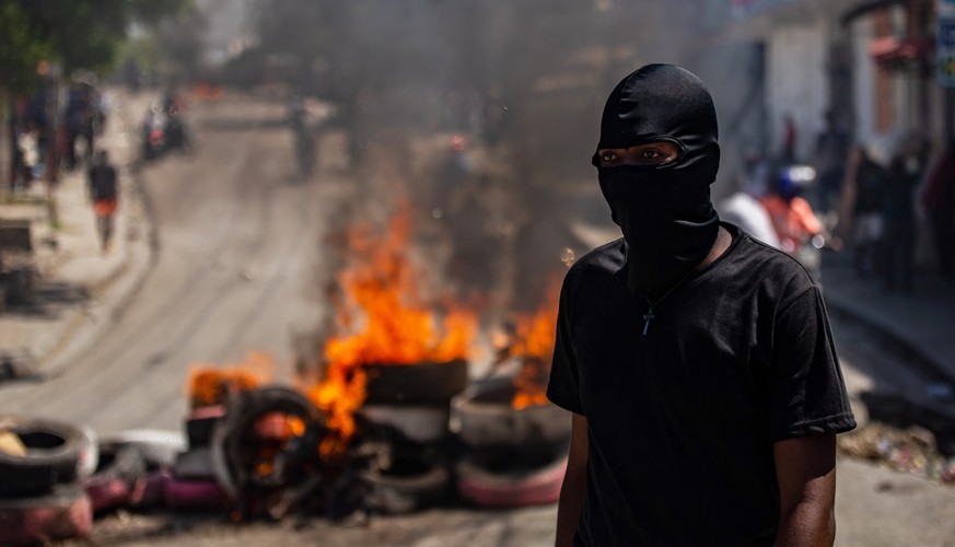 epa11555748 A demonstrator stands near a fire barricade during a protest against gang violence in the Solino neighborhood of Port-au-Prince, Haiti, 19 August 2024. EPA/MENTOR DAVID LORENS