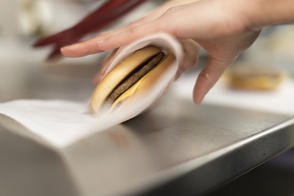 An employee wraps a cheeseburger in paper in the kitchen of a McDonald&#039;s restaurant in Hinwil, Canton of Zurich, Switzerland, on January 25, 2017. (KEYSTONE/Gaetan Bally)