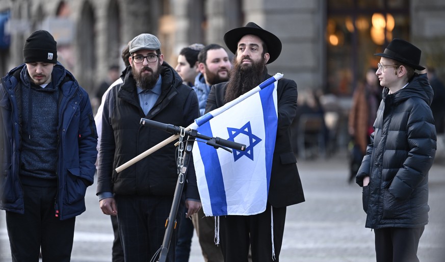 epa11197071 People gather in Helvetiaplatz during a rally against anti-Semitism, one day after a Jewish man was stabbed, in Zurich, Switzerland, 03 March 2024. People carried yellow umbrellas as a sym ...